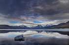 Clouds reflect in opening in the ice on Lake McDonald in Glacier National Park, Montana, USA. Art Print